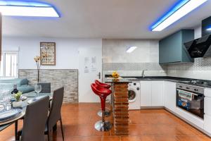 eine Küche und ein Esszimmer mit Tisch und Stühlen in der Unterkunft MalagaSuite Casa Rural Alcaucin in Alcaucín