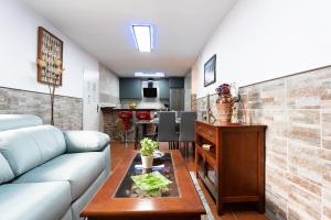 ein Wohnzimmer mit Sofa und Tisch in der Unterkunft MalagaSuite Casa Rural Alcaucin in Alcaucín