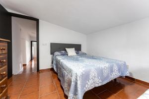ein Schlafzimmer mit einem Bett mit einer blau-weißen Decke in der Unterkunft MalagaSuite Casa Rural Alcaucin in Alcaucín + 37 Fotos