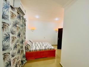 a bedroom with a bed with a tropical wallpaper at Chez soi loin de chez soi in Pointe-Noire