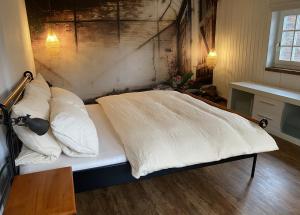 Una cama con sábanas blancas y almohadas en una habitación. en Haus Auenland, en Groß Felda