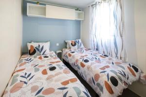 Un dormitorio con dos camas y una ventana. en Camping Les Oyats, en Seignosse 17 fotos más