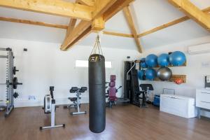 Un gimnasio con un saco de boxeo en una sala con aparatos de ejercicio. en Camping Les Oyats, en Seignosse