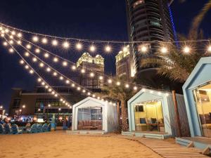a string of lights over a beach at night at Hilton Doha in Doha