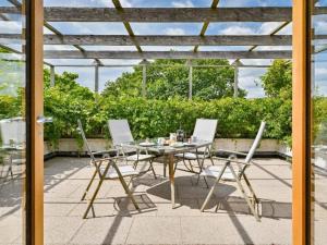 a table and chairs on a patio with a pergola at Holiday Home Rivers Reach by Interhome in Bere Alston