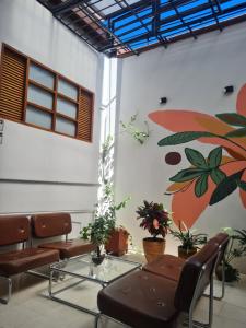 a waiting room with chairs and a painting on the wall at Casa Moore in Medellín