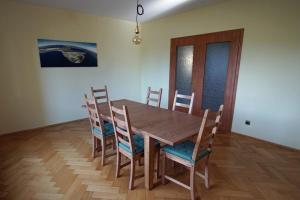 a wooden dining room table and chairs in a room at Gemütliche Ferienwohnung in Krina mit Garten und Grill in Krina +14 photos