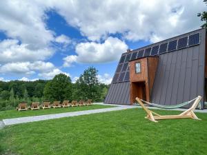 un gruppo di sedie e un edificio con pannelli solari di Dream Cottage a Paltin