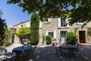 a stone house with tables and chairs in front of it at Gite Grand Luberon chez Manon en Luberon - Vacation rental in guest house in Lagnes