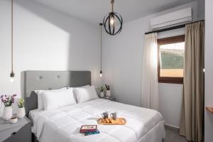 Un dormitorio con una cama blanca y una bandeja. en Iris Villa 3 - Archanes Crete, en Káto Arkhánai