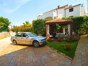 un coche aparcado delante de una casa en Ferienwohnung für 8 Personen ca 110 qm in Fažana, Istrien Istrische Riviera, en Fažana
