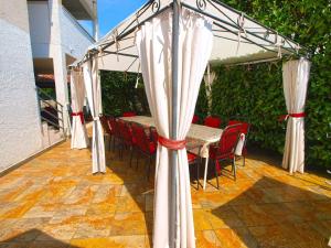 un patio con mesa y sillas bajo un dosel en Ferienwohnung für 8 Personen ca 110 qm in Fažana, Istrien Istrische Riviera, en Fažana
