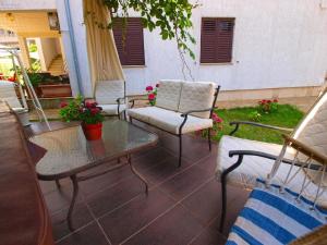 un patio con 2 sillas, una mesa y sillas en Ferienwohnung für 8 Personen ca 110 qm in Fažana, Istrien Istrische Riviera, en Fažana 14 fotos más