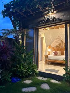 a bedroom with a bed on a patio at Dales Villa in Ubud