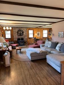JohnsburgにあるHannah's Birch Farm 10 Min to Gore Ski Mt.のソファと暖炉のある広いリビングルーム