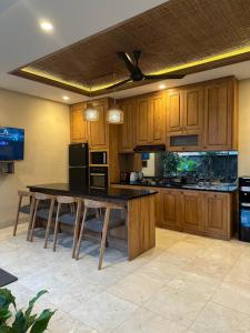 a kitchen with wooden cabinets and a table with benches at Dales Villa in Ubud