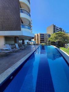 uma grande piscina em frente a um prédio em Prédio à beira-mar, na melhor localização do Rio Vermelho. em Salvador