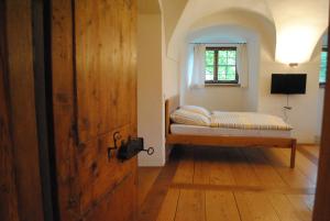a bedroom with a bed in a room with a window at Schloss Hofstetten Ingerle-Klause in Hofstetten
