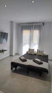 a large bed in a white room with a window at AM Chinorros Square. in Fuengirola