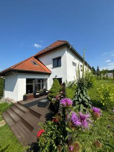 a house with a deck and flowers in the yard at Hotel Vincent in Luhačovice