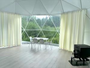 a room with a table and chairs in a tent at Bubble House glamping telk in Sõmeru