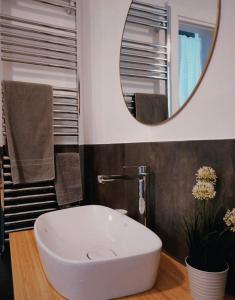 un bagno con un lavandino bianco e uno specchio di Le Casette a La Spezia