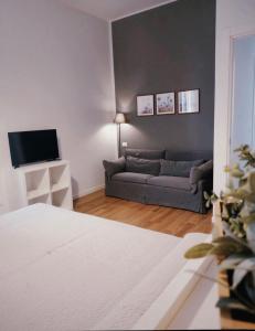 un soggiorno con un divano e una televisione di Le Casette a La Spezia