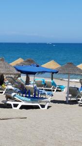 a group of chairs and umbrellas on a beach at AM Chinorros Square. in Fuengirola