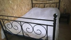 a black bed with a white blanket on it at Chalet Le Breuil in La Chapelle-Taillefert