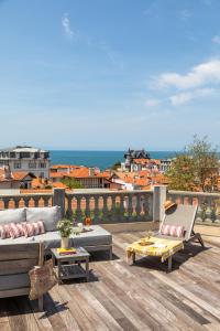 a patio with a couch and chairs on a deck at Hotel de Silhouette in Biarritz