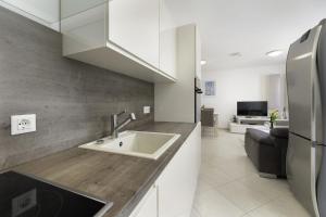 une cuisine avec un évier et un réfrigérateur dans l'établissement Ferienwohnung für 5 Personen ca 60 qm in Uvala Soline, Kvarner Bucht Krk, à Soline