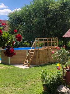 a wooden swimming pool with a slide in a yard at Tornácos Vendégház Kápolnásnyék in Kápolnásnyék