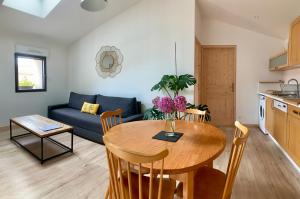 a kitchen and living room with a table and a couch at Le Solier, gîte à la campagne in Frossay +6 photos