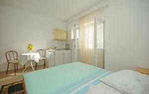 a bedroom with a bed and a table and a kitchen at White Hill Studio-Apartments in Makarska
