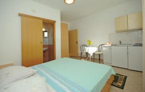 a bedroom with a large bed and a kitchen at White Hill Studio-Apartments in Makarska +24 photos