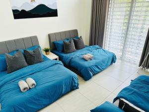 大山脚BM大山脚 Double Storey Terrace Autocity Alma Aeon Jusco Nearby的配有蓝色床单的客房内的两张床