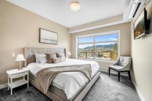 ein Schlafzimmer mit großem Bett und Fenster in der Unterkunft Top Floor Apartment at Amenity Rich Resort 406 in West Kelowna + 48 Fotos