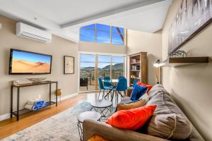 ein Wohnzimmer mit Sofa und Fernseher in der Unterkunft Top Floor Apartment at Amenity Rich Resort 406 in West Kelowna