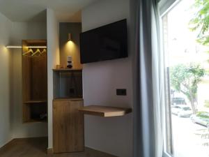 a living room with a flat screen tv on a wall at Plaza Rooms in Totana
