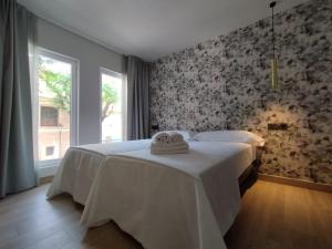 a bedroom with a bed with a towel on it at Plaza Rooms in Totana