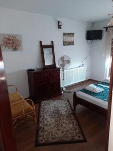 a room with a bed and a dresser and a mirror at Къща за гости Сара in Velingrad