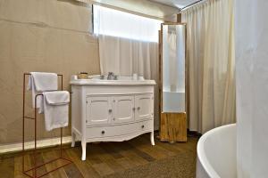 a bathroom with a white sink and a tub at HMO Glamping & Suites in Vignanotica in Mattinata