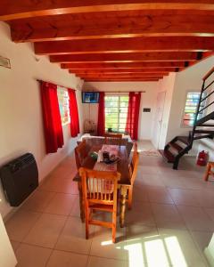 a dining room with red curtains and a table and chairs at Un lugar en Monte in San Miguel del Monte +17 photos