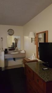 a room with a bathroom with a sink and a mirror at Travelodge by Wyndham Indio in Indio