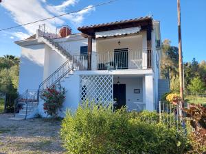 a white house with a balcony and stairs at Deiana's Apartment - Cardedu Beachside in Cardedu