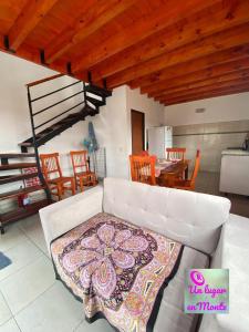 a living room with a white couch and a table at Un lugar en Monte in San Miguel del Monte