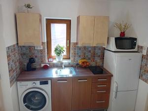 una cucina con lavello e lavatrice di Edi apartman a Vecsés