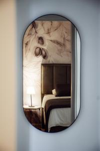 a mirror reflecting a bedroom with a bed in it at Apartments Petra in Risika +45 photos