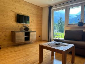 un salon avec un canapé et une table dans l'établissement Walser Berge Appartements, à Mittelberg