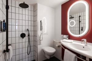 a bathroom with a toilet and a sink and a mirror at ibis Lausanne Centre in Lausanne +66 photos